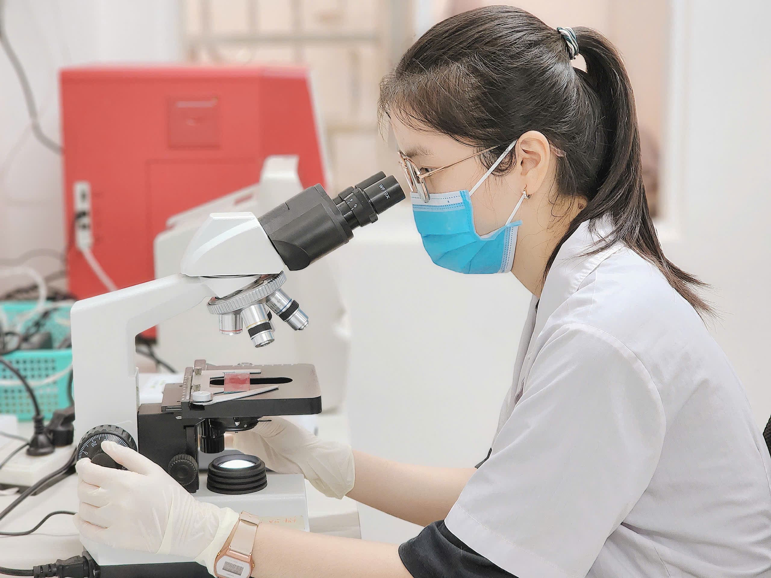 Kỹ thuật viên Pet One quan sát mẫu xét nghiệm qua kính hiển vi
